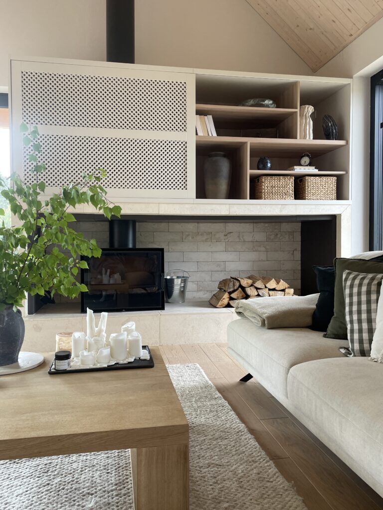 Przytulne wnętrze z kominkiem zaprojektowane przez SOHA Design – przykład kompleksowego projektowania wnętrz łączącego funkcjonalność, estetykę i spokój.