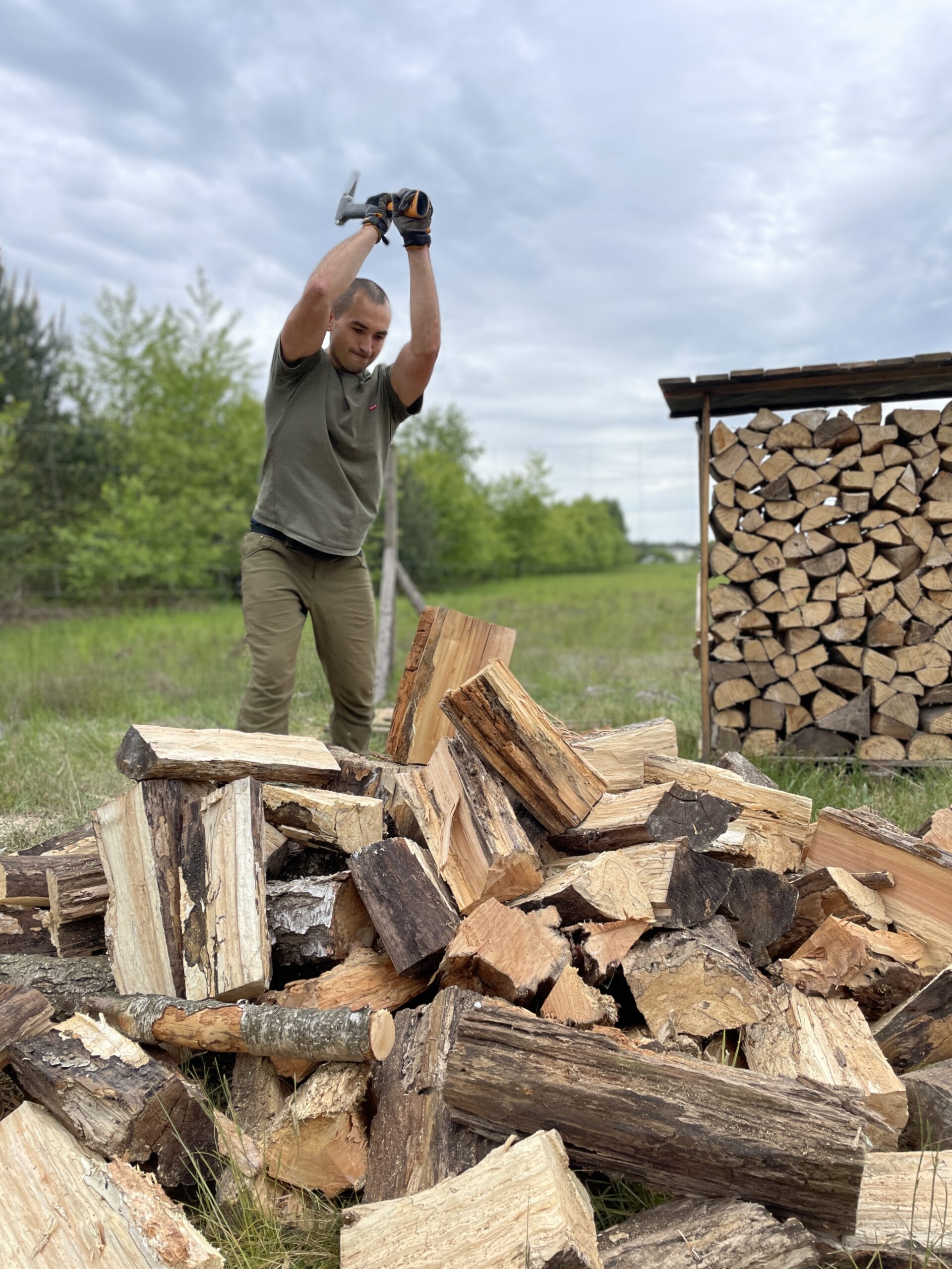 Mężczyzna przygotowujący drewno w trakcie budowy domu – symbol świadomego podejścia do organizacji budowy i tworzenia przestrzeni z zaangażowaniem oraz troską o każdy detal.